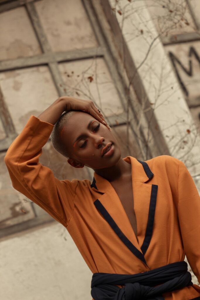 Stylish woman posing outdoors in fashionable attire, captured in a warm and moody setting in Rio de Janeiro.